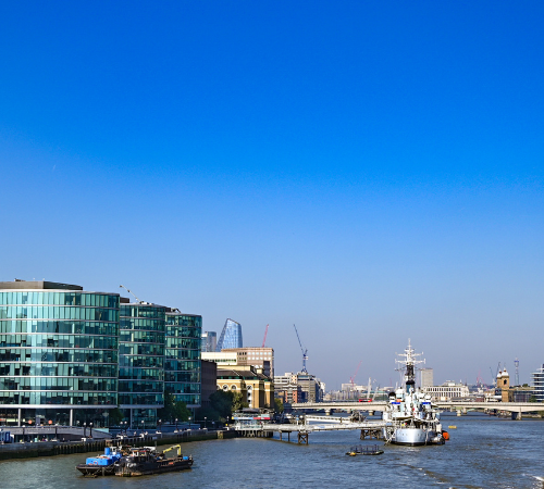 Image of the river Thames with the shard on the left. A boat is sailing in the centre.